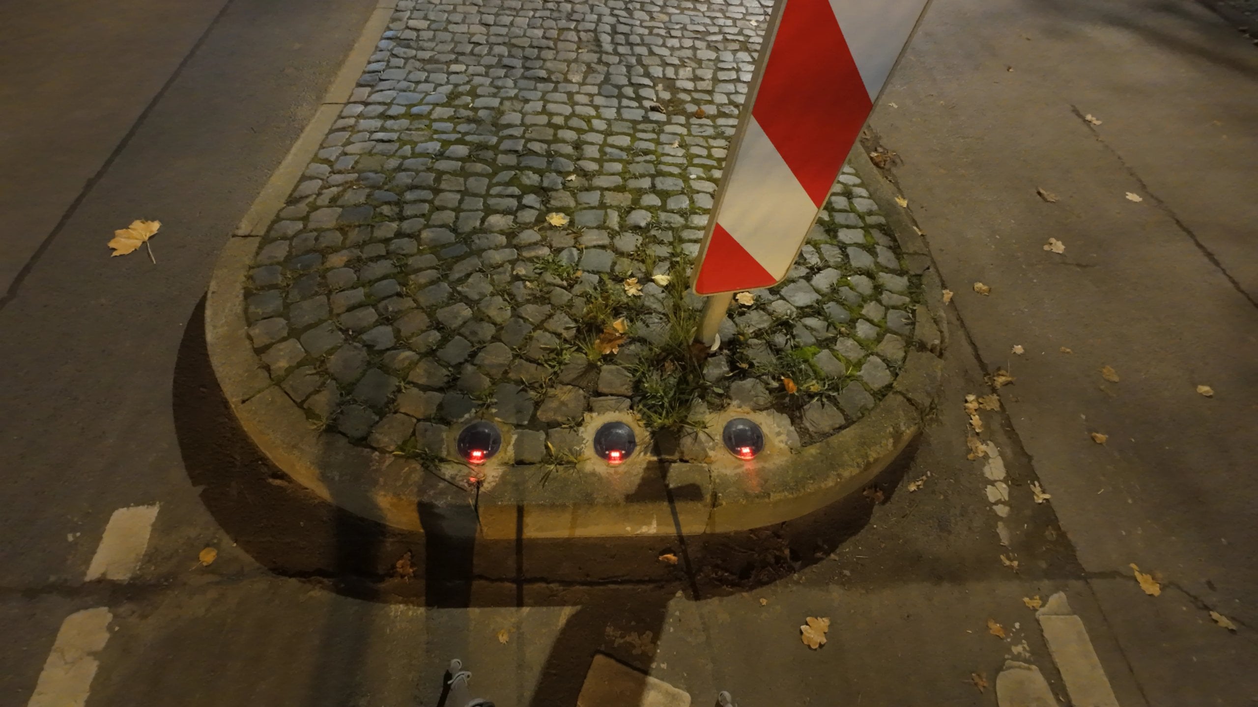 Traffic island with cobblestones, three Road Studs set into the tip of the island