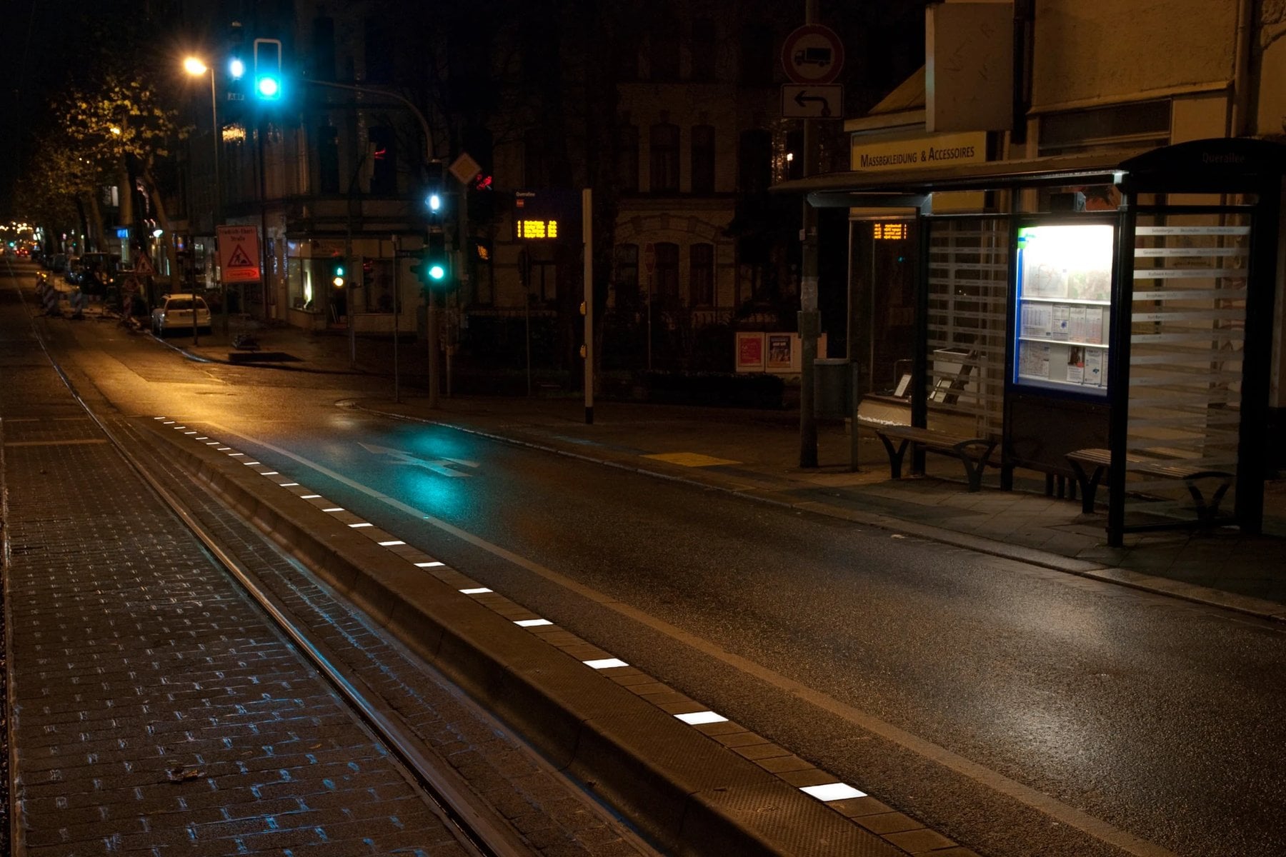 Tram stop at night, illuminated stones mark the platform edge