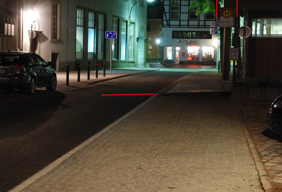 Haltestelle bei Nacht, der Lichtkegel der Mastleuchte liegt abseits des Einstiegs