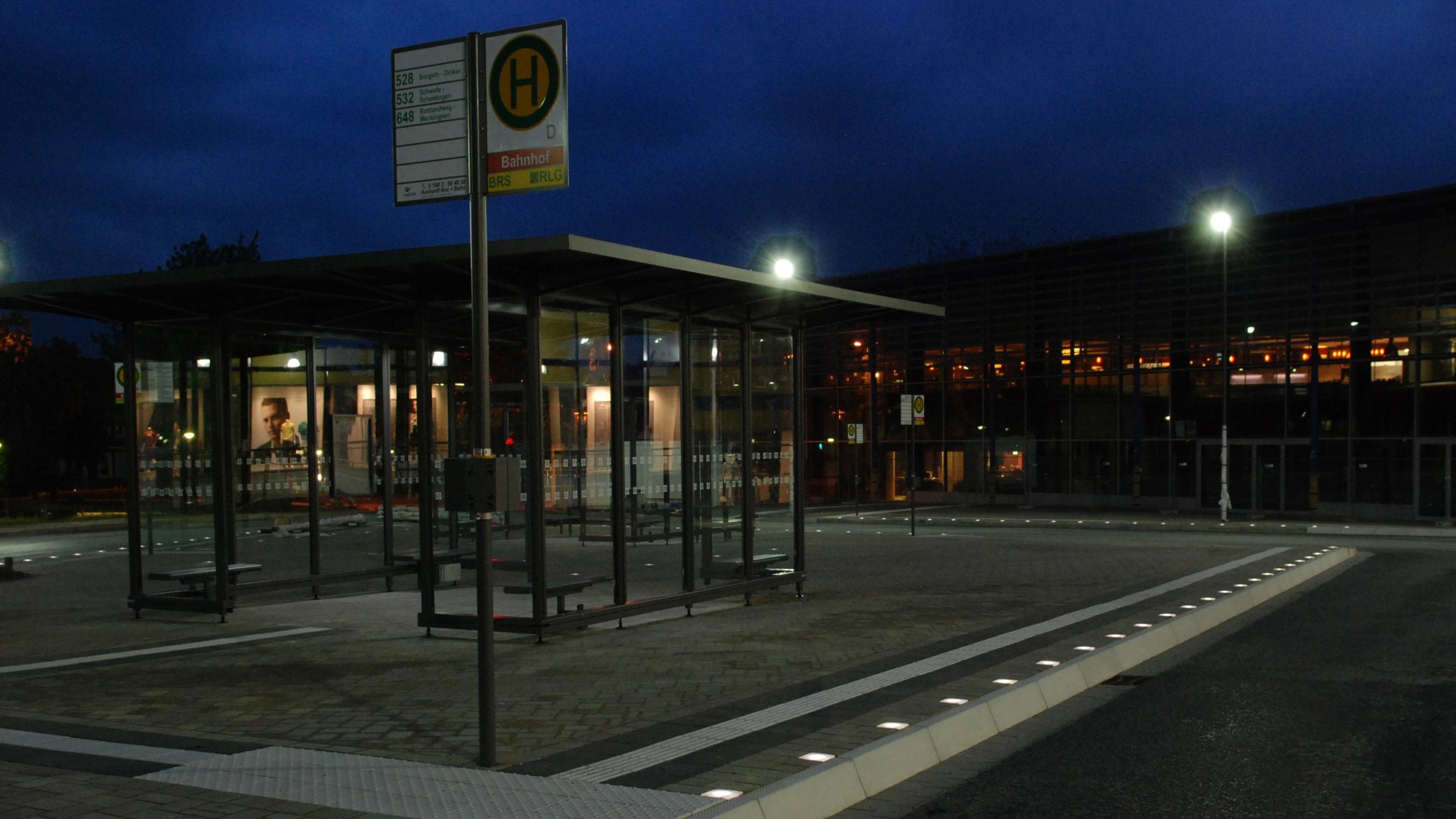 Public transport stop at dusk, Paver Lights along the platform edge