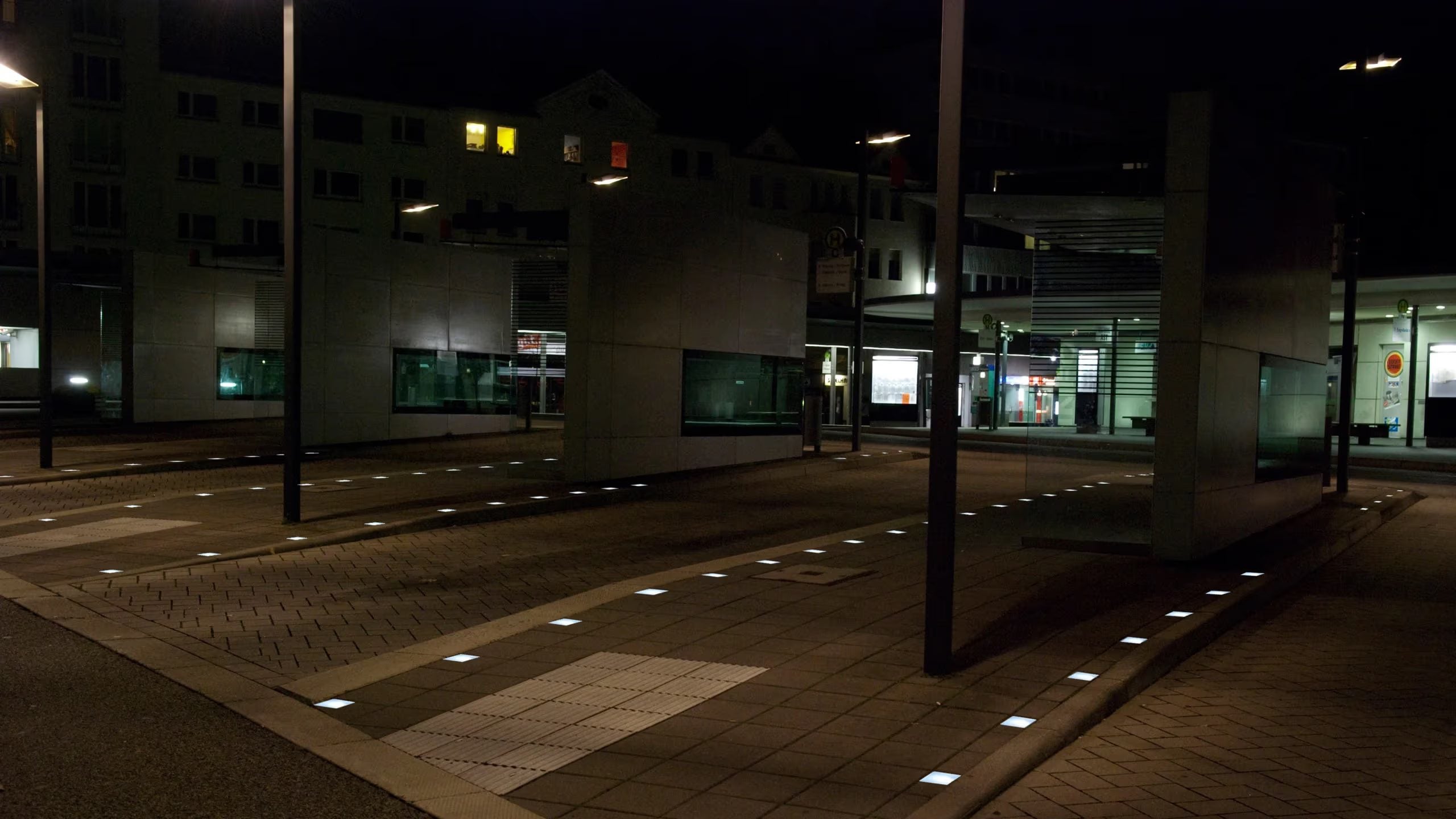 Busbahnhof bei Nacht, Lightstone LED-Pflastersteine zeichnen den Bussteig nach