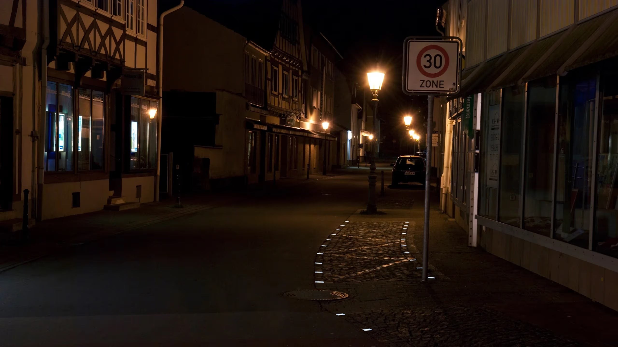 Haltestelle in der Altstadt bei Nacht, Lightstone LED-Pflastersteine im Kopfsteinpflaster vor Fachwerkhäusern