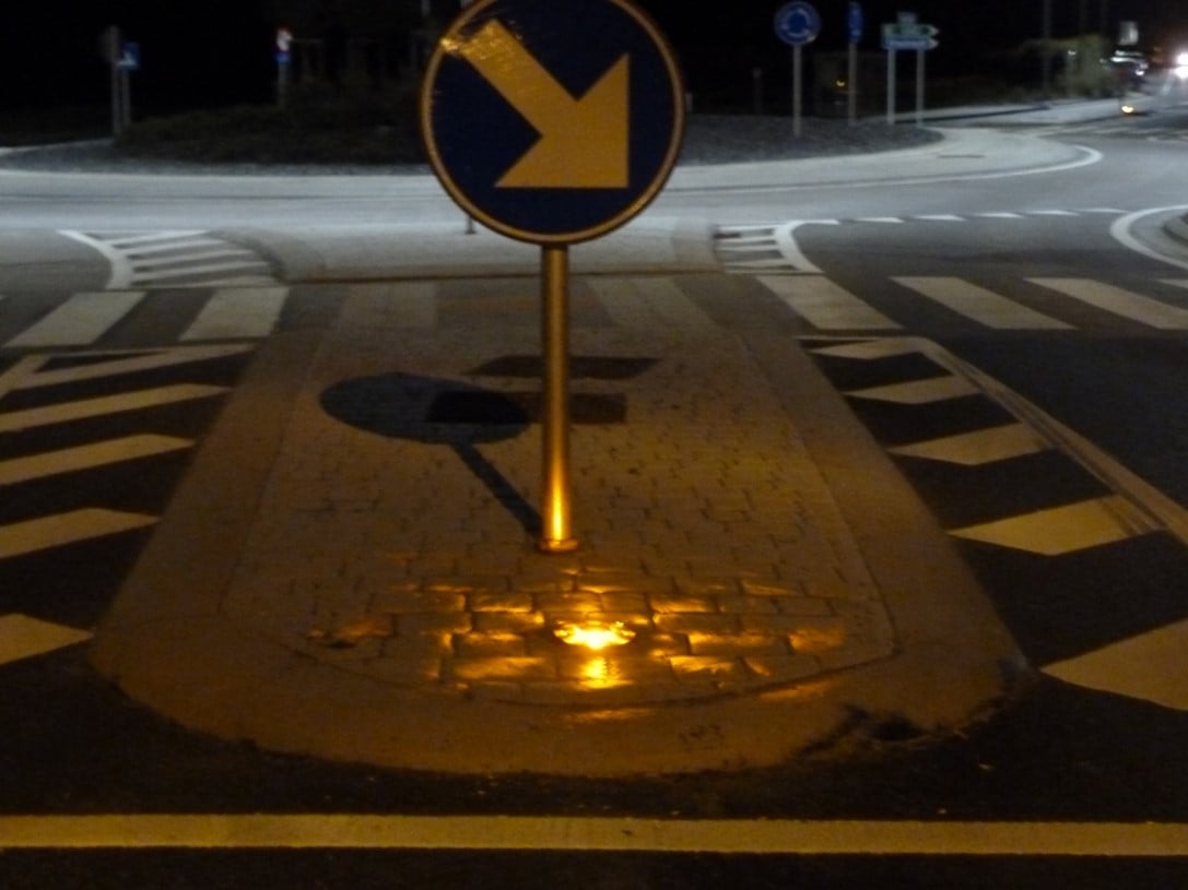 Verkehrsinsel bei Nacht, eine STARWAY leuchtet bodennah unter dem Richtungsschild